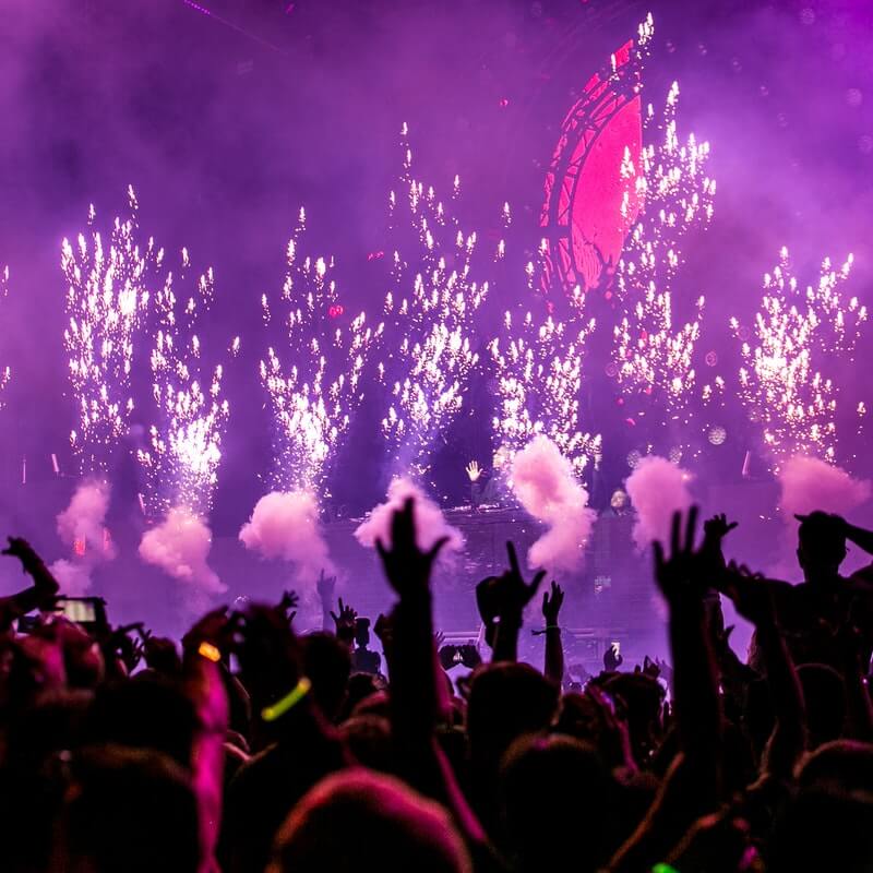 Szene auf einer Party, mit Feuerwerk, Rauch und Händen in der Luft